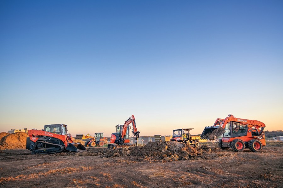 The tractors around a dirt pile.