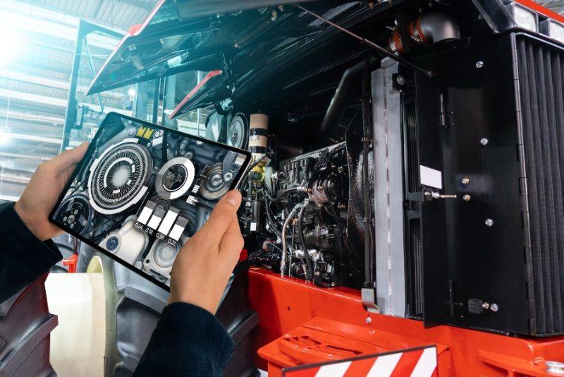 Man looking at ipad connected to engine Mission Valley Kubota